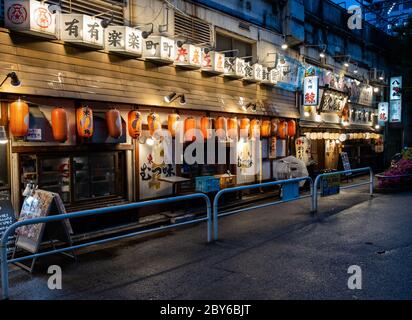 Kleine Restaurants und ein japanischer Pub oder Izakaya in der Hintergasse des Yurakucho-Viertels, Tokio, Japan bei Nacht. Stockfoto