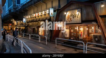 Leute, die in der Hintergasse des Yurakucho-Bezirks, Tokio, Japan bei Nacht spazieren gehen. Stockfoto