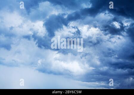 Stürmisches Wolkenhimmel-Panorama, dramatische dunkelblaue Gewitterwolken, weiße flauschige Cumulus-Wolken aus nächster Nähe, Gewitterlandschaft, trübes Schlechtwetter Stockfoto