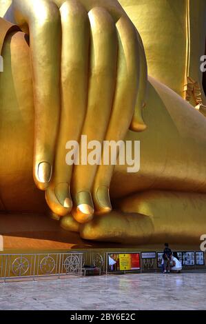 Hand des größten goldenen Buddha in thai Tempel von in Thailand und drei Mönche Stockfoto