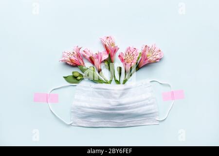 Danke Helden Doktor und Krankenschwestern Konzept mit medizinischen Maske und rosa Blumen auf blauem Hintergrund. Stockfoto