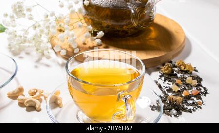 Eine Tasse grüner Tee und eine Teekanne. Blumentee mit Obstscheiben. Teezeremonie, traditionelles Getränk. Nachmittagstee, heimelig. Flaches Lay. Orientalisch, gemütlich, vorher Stockfoto