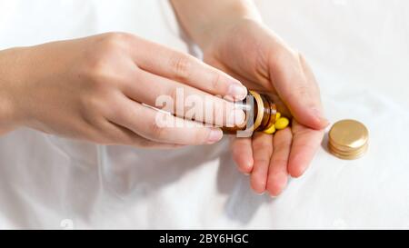 Nahaufnahme Bild von Frau Gießen Pillen aus der Flasche auf ihre Hand Stockfoto