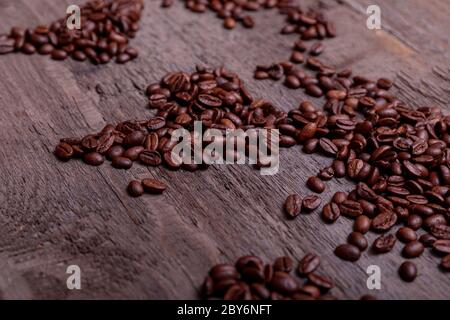 Dramatische Foto der Weltkarte aus arabisch gerösteten Kaffeebohnen auf alten Vintage-Holztisch. Stockfoto