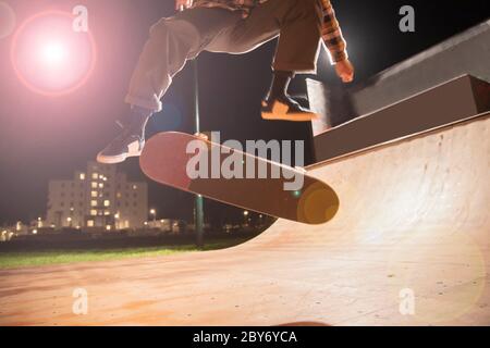 Junger Mann Skateboarding auf Rampe im Skatepark Stockfoto