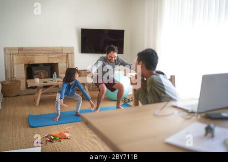 Vater und Tochter trainieren im Wohnzimmer Stockfoto