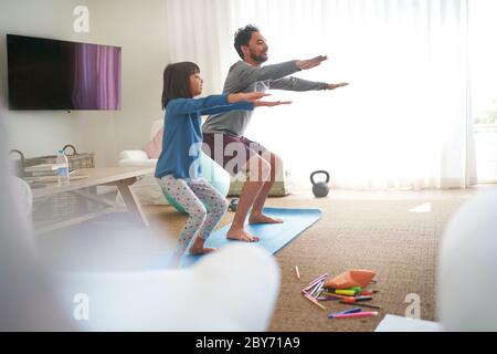 Vater und Tochter trainieren im Wohnzimmer Stockfoto