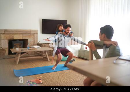 Spielerisch Vater und Tochter trainieren im Wohnzimmer Stockfoto