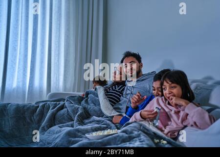Portrait glücklicher Mann entspannend und Film mit Familie auf dem Sofa Stockfoto