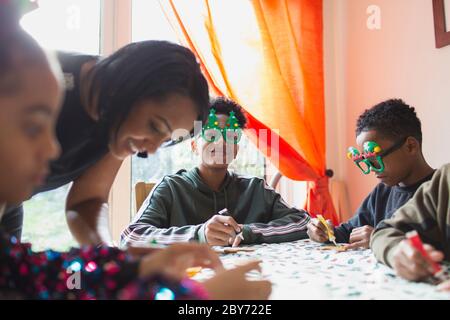 Portrait glücklich Junge Dekoration Weihnachtskekse mit Familie am Tisch Stockfoto