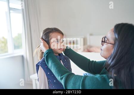 Mutter hilft Tochter Haar zu reparieren Stockfoto