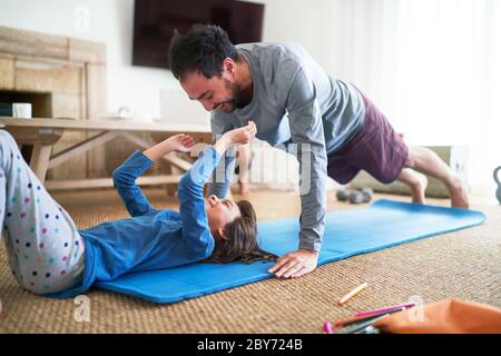 Spielerisch Vater und Tochter trainieren im Wohnzimmer Stockfoto