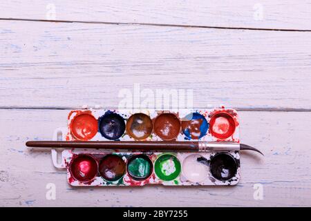 Professionelle Aquarellfarben in Box mit Pinsel auf alten weißen Holzbrett Stockfoto
