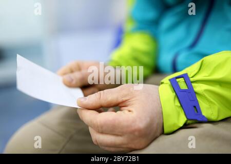 Mann hält in den Händen Blatt Papier mit Nummer in der Linie Stockfoto