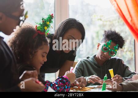 Familie dekorieren Weihnachtskekse am Tisch Stockfoto