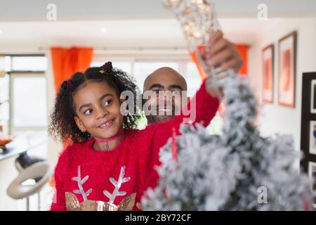 Glücklicher Vater und Tochter schmücken weihnachtsbaum Stockfoto