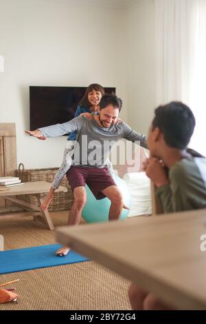 Spielerisch Vater und Tochter trainieren im Wohnzimmer Stockfoto