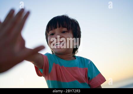 Fröhlicher Junge, der sich verfünffgt Stockfoto