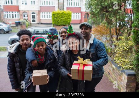 Portrait glückliche Familie mit Weihnachtsgeschenken in der Einfahrt Stockfoto