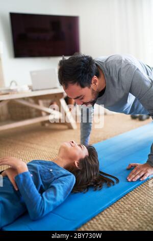 Spielerisch Vater und Tochter trainieren im Wohnzimmer Stockfoto