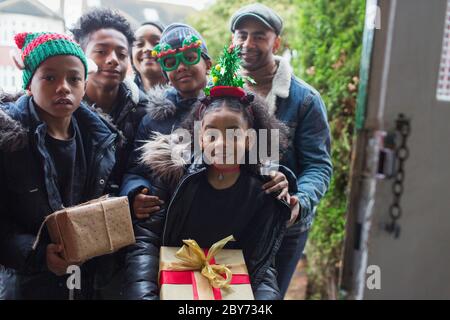 Portrait glückliche Familie liefern Weihnachtsgeschenke an der Haustür Stockfoto