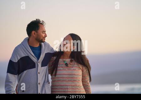 Glückliches liebevolles Paar umarmt am Strand Stockfoto