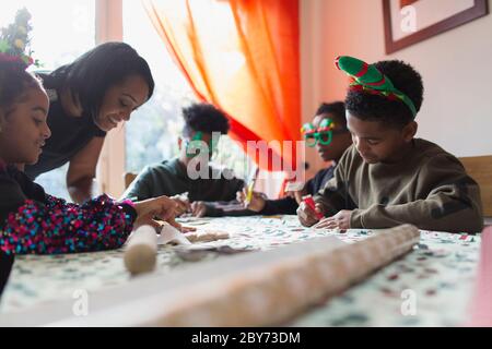 Familie dekorieren Weihnachtskekse am Tisch Stockfoto