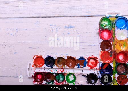 Professionelle Aquarellfarben in Box mit Pinsel auf alten weißen Holzbrett Stockfoto