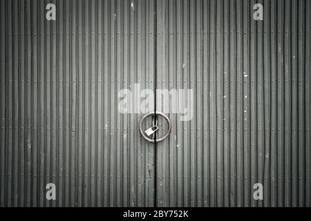 Graugraue Metalltüren mit grauem Verwitterungseinflüssen. Altes verwittertes Eisentor. Stockfoto