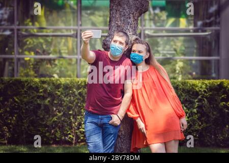 Junge Menschen, die Spaß machen Selfie im Freien tragen schützende Gesichtsmasken Stockfoto