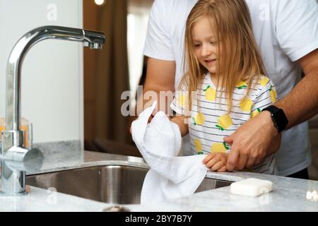 Vater und Tochter waschen sich die Hände über dem Waschbecken in einer Küche Stockfoto