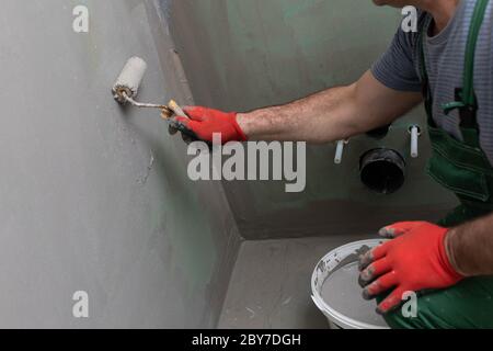 Badezimmer renoviert. Bauarbeiter. Isolierung mit mineralischer Feuchtigkeit. Während der Arbeit. Stockfoto