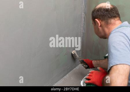 Badezimmer renoviert. Bauarbeiter. Isolierung mit mineralischer Feuchtigkeit. Während der Arbeit. Stockfoto