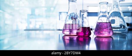 Lila Glasflasche in blauem Licht Forschung Chemie Wissenschaft Banner Labor Hintergrund Stockfoto