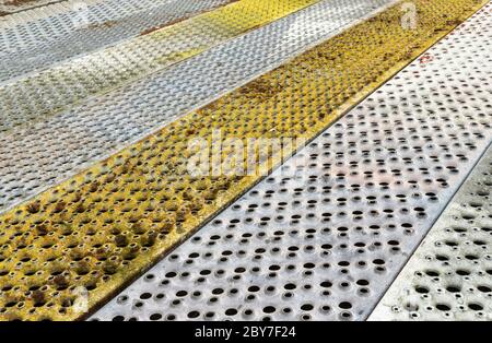 Metall Hintergrund mit Perforation von quadratischen Löchern. Graue und bunte Stahlstruktur aus Sandblech Stockfoto