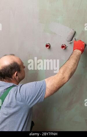 Badezimmer renoviert. Bauarbeiter. Isolierung mit mineralischer Feuchtigkeit. Während der Arbeit. Stockfoto