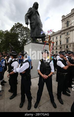 Polizei bildet sich um die Sir Winston Churchill Statue auf dem Parliament Square, London, vor einer Kundgebung an der Nelson Mandela Statue auf dem Platz, um George Floyd zu gedenken, Als seine Beerdigung findet in den USA nach seinem Tod am 25. Mai, während in Polizeigewahrsam in der US-Stadt Minneapolis. Stockfoto