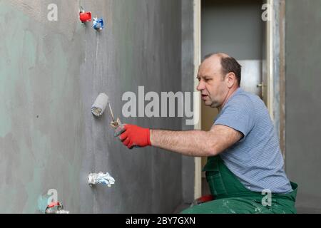 Badezimmer renoviert. Bauarbeiter. Isolierung mit mineralischer Feuchtigkeit. Während der Arbeit. Stockfoto