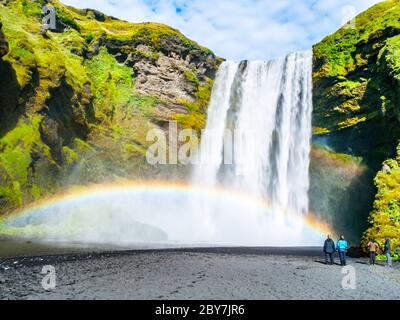 Skogafoss - einer der schönsten Wasserfälle an sonnigen Tag mit Regenbogen, Skogar, Island. Stockfoto