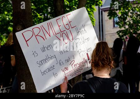 Eine Frau hält ein Zeichen über weiße Privilegien, während Tausende sich in der Innenstadt von Ottawa, Kanada, versammeln, um gegen Polizeigewalt und Rassismus zu protestieren. Stockfoto