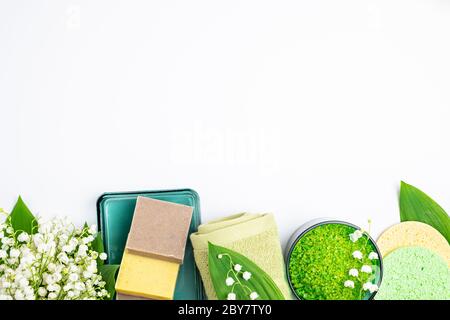 Wellness-Behandlung Wellness-Konzept. Natürliche Spa Kosmetikprodukte, Handtücher, Accessoires, Badeschwamm, Seife, Kräuter Meersalz, Blumen auf weißem Hintergrund. Stockfoto