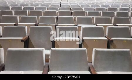 Viele alte beige Polsterstühle ohne Menschen in der Halle für Aufführungen und Filme. Hintergrund von vielen Stühlen in den Ständen in einem Konzert ha Stockfoto
