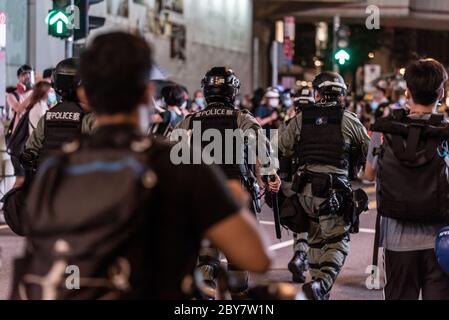 Hongkong, China. Juni 2020. Die Polizei von Hongkong stürmt in die Menge, während Hunderte von Honkongers sich einem Polizeiverbot widersetzen und die Straßen im zentralen Geschäftsviertel erobern, um den einjährigen Jahrestag der prodemokratischen Proteste in Hongkong zu begehen. Quelle: Ben Marans/Alamy Live News. Stockfoto