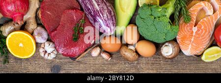 Gesunde Ernährung Hintergrund. Auswahl an ausgewogenen Lebensmitteln für eine gesunde Ernährung. Frisches Fleisch Rindfleisch Steaks, Fisch Lachs, Obst, Gemüse. Langes Webformat Stockfoto