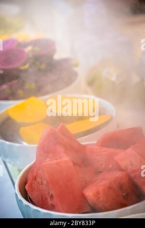 Schalen mit frisch geschnittenen köstlichen saftigen Früchten zum Verkauf auf dem Markt in China Stockfoto