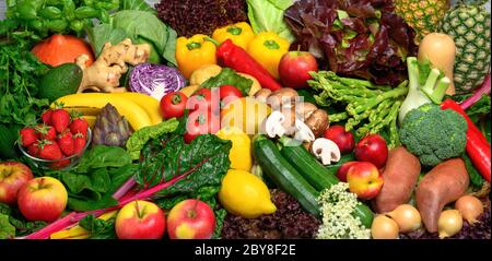 Ein Stapel Obst und Gemüse in vielen appetitlichen Farben angeordnet, lädt zu einem gesunden pflanzlichen Lebensstil und Selbstversorgung führen Stockfoto