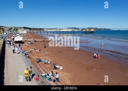 Blick entlang des Strandes zum Pier im Sommer, Paignton, Devon, England, Großbritannien Stockfoto