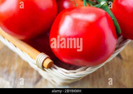 Frische Bio-Tomaten in einem gewebten Korb. Nahaufnahmen Stockfoto