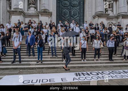 VENEDIG, ITALIEN - JUNI 09: Reiseführer (in Weiß gekleidet) und Reiseleiter (in Schwarz gekleidet) protestieren, um ihre Arbeit in der Kirche von Salute zurückzubekommen Stockfoto