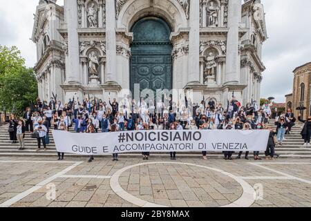 VENEDIG, ITALIEN - JUNI 09: Reiseführer (in Weiß gekleidet) und Reiseleiter (in Schwarz gekleidet) protestieren, um ihre Arbeit in der Kirche von Salute zurückzubekommen Stockfoto